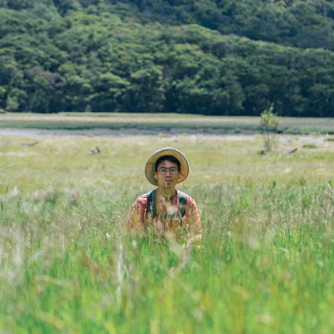 He is smiling in the grass